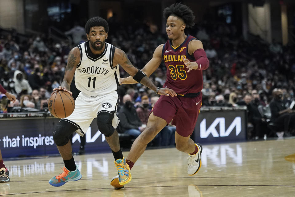 Brooklyn Nets' Kyrie Irving (11) drives against Cleveland Cavaliers' Isaac Okoro (35) in the second half of an NBA basketball game, Monday, Jan. 17, 2022, in Cleveland. (AP Photo/Tony Dejak)