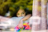 Mariscal peers out of the window of the home where she was poisoned by lead-based paint in Hayward