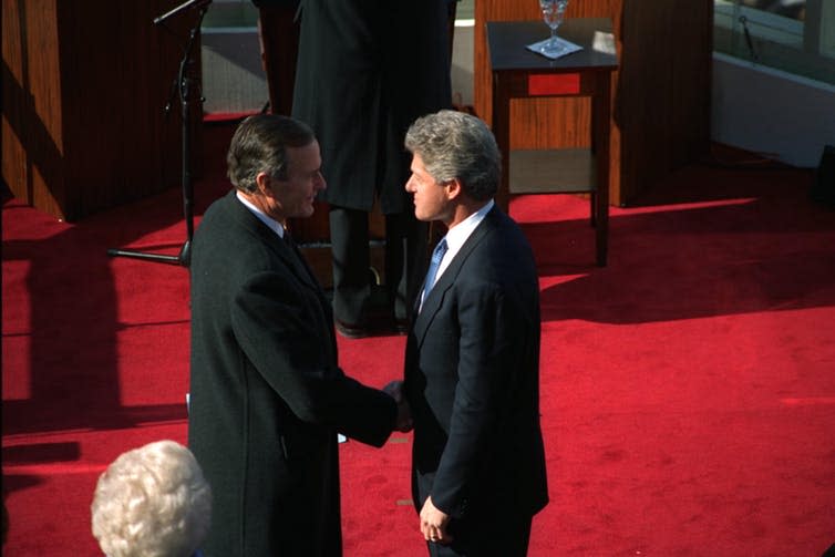 <span class="caption">Passing the torch: Bill Clinton takes over from George Bush Senior.</span> <span class="attribution"><a class="link " href="https://commons.wikimedia.org/wiki/File%3A1993_Clinton_and_Bush_Inauguration.jpg" rel="nofollow noopener" target="_blank" data-ylk="slk:Smithsonian via Wikimedia Commons;elm:context_link;itc:0;sec:content-canvas">Smithsonian via Wikimedia Commons</a></span>