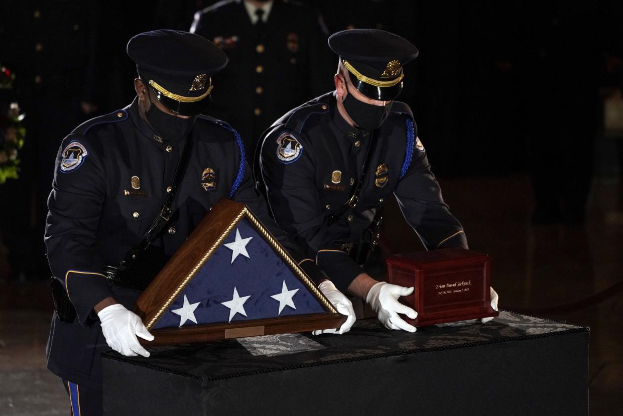 US Capitol Police Officers place the urn holding the remains of fellow officer Brian Sicknick on a stand to lie in honor in the Capitol Rotunda in Washington, February 2, 2021.