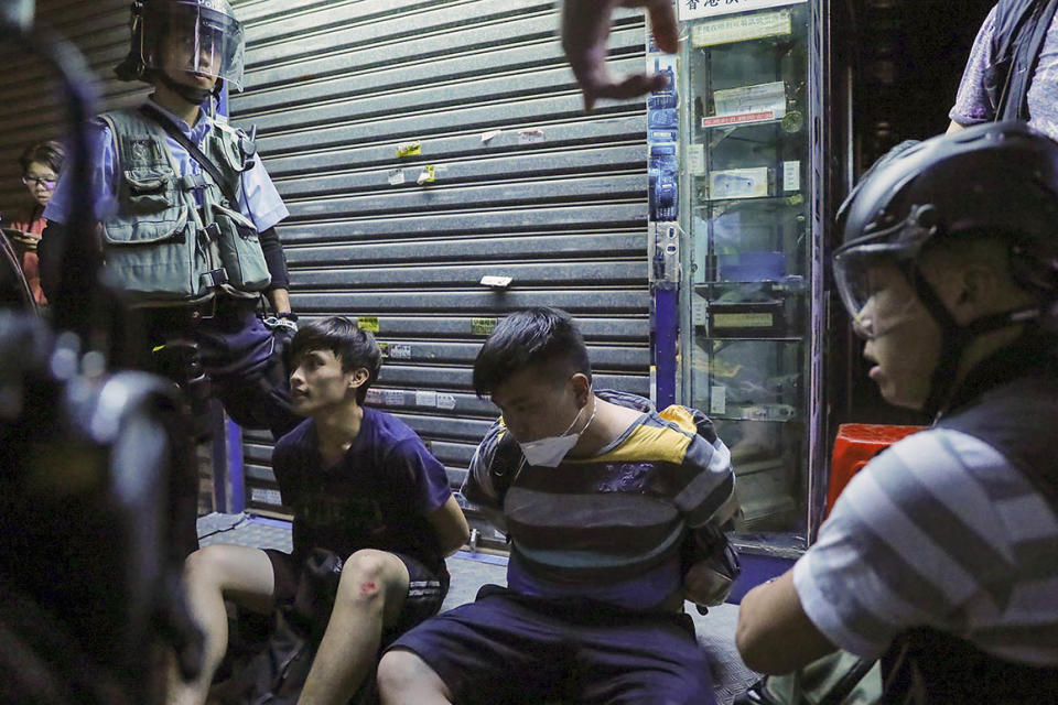 People arrested by policemen during a face off at Sham Shui Po district in Hong Kong on Wednesday.