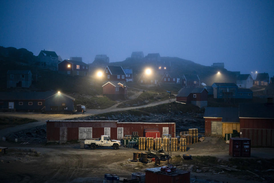 In this Aug. 15, 2019, photo, early morning fog shrouds homes in Kulusuk, Greenland. In tiny Kulusuk, resident Mugu Utuaq says the winter that used to last as long as 10 months when he was a boy, can now be as short as five months. Scientists are hard at work in Greenland, trying to understand the alarmingly rapid melting of the ice. (AP Photo/Felipe Dana)