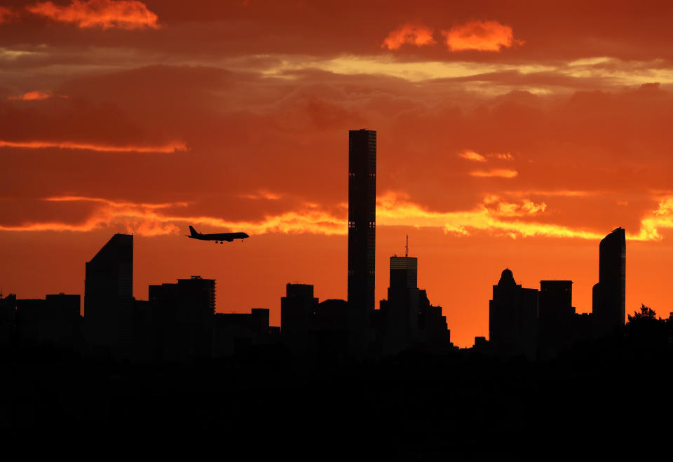 FILE - In this Sept. 6, 2016, file photo, a plane flies near the Manhattan skyline at sunset in New York. The latest mass shootings in the United States have triggered multiple countries to warn their citizens to be wary of travel conditions there. (AP Photo/Darron Cummings, File)