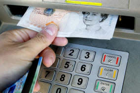 File photo dated 04/04/06 of a person withdrawing money from a cashpoint as current account providers are using a myriad of baffling charging structures that make it almost impossible to calculate and compare the cost of slipping into an unauthorised overdraft, research from Which? has found. PRESS ASSOCIATION Photo. Issue date: Friday January 17, 2014. The consumer group made its findings after asking 18 volunteers, including a principal inspector of taxes and a retired headteacher to calculate from a mock statement what this cost would be by looking at banks' and building societies' charging structures on their websites. The volunteers got just 10 out of 72 calculations correct between them, with the tax inspector getting just one of his four calculations right and the former headteacher getting them all wrong. It also took people 10 minutes on average even to find the charges on current account providers' websites - and in some cases it took longer than half an hour. See PA story MONEY Charges. Photo credit should read: Gareth Fuller/PA Wire