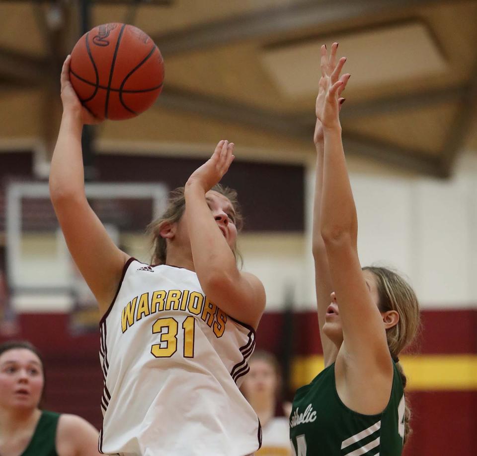 Megan Taraba, left, of Walsh Jesuit goes up for two points over Mila Udovicic of Lake Catholic during the third period of their game at Walsh Jesuit High School in Cuyahoga Falls Wednesday night. Walsh won 48-28. 