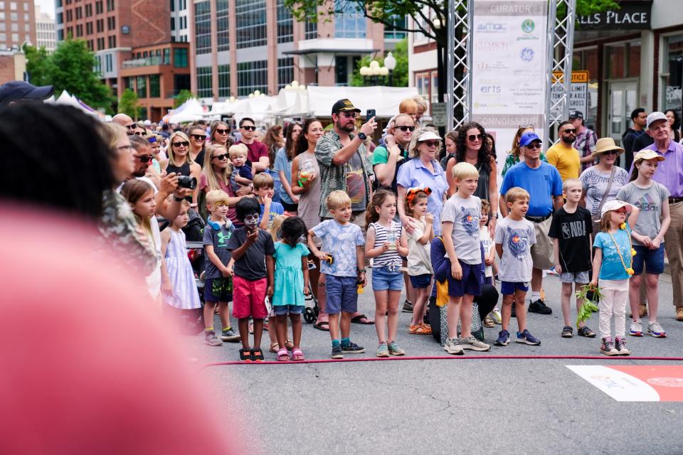 Images of Artisphere 2022, as children and adults look into the downtown crowd during the three-day festival