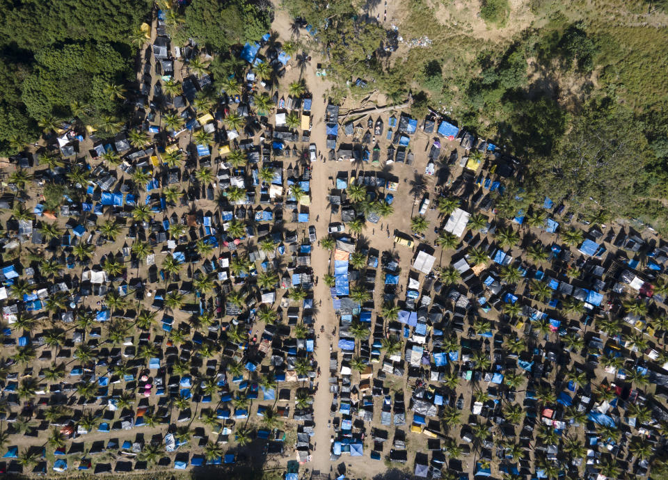 FILE - In this May 26, 2021 file photo, tents and shacks cover land designated for a Petrobras refinery, called the "First of May Refugee Camp," which refers to the date the squatters camp sprung up amid the new coronavirus pandemic, in Itaguai, Rio de Janeiro state, Brazil. As Brazil hurtles toward an official COVID-19 death toll of 500,000, President Jair Bolsonaro has waged a campaign to downplay the virus’s seriousness and keep the economy humming. (AP Photo/Mario Lobao, File)