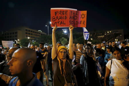 A supporter of Elor Azaria, an Israeli soldier charged with manslaughter by the Israeli military after he shot a wounded Palestinian assailant as he lay on the ground in Hebron on March 24, holds a sign during a protest calling for his release in Tel Aviv, Israel April 19, 2016. REUTERS/Baz Ratner