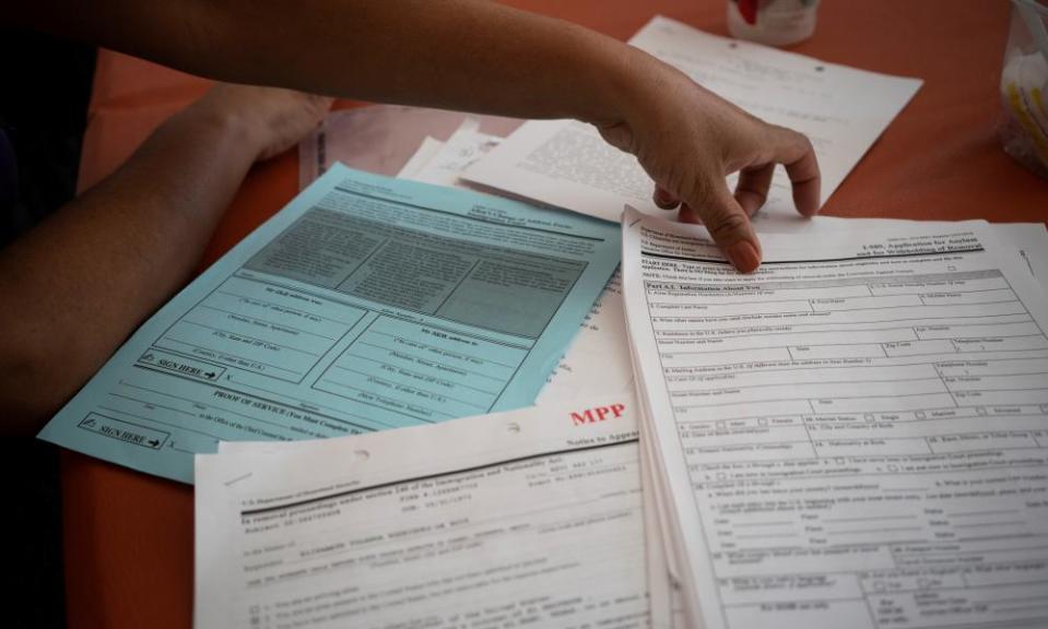 A migrant from El Salvador shows her documents from Migrant Protection Protocols on 16 June.