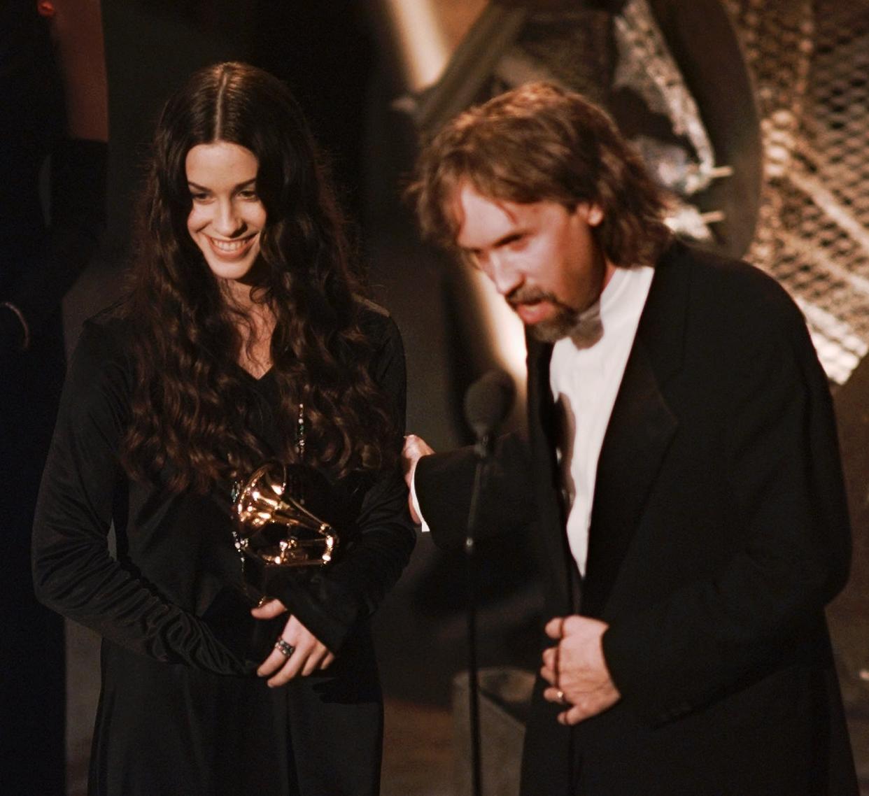 Alanis Morissette and record producer Glen Ballard accept the award for Album of the Year at the 38th annual Grammy Awards. (Photo: AP/Eric Draper)