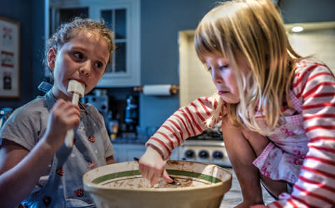 Amelie and Izzy licking the bowl after making a cake - Credit: Dan Rivers  /This Is Britain