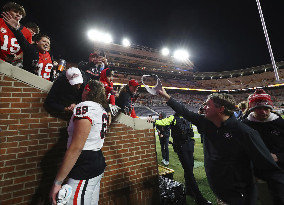 Georgia head coach Kirby Smart, right, tips his cap as he and his players leave the field after an NCAA college football game against Tennessee, Saturday, Nov. 18, 2023, in Knoxville, Tenn. (Curtis Compton/Atlanta Journal-Constitution via AP)