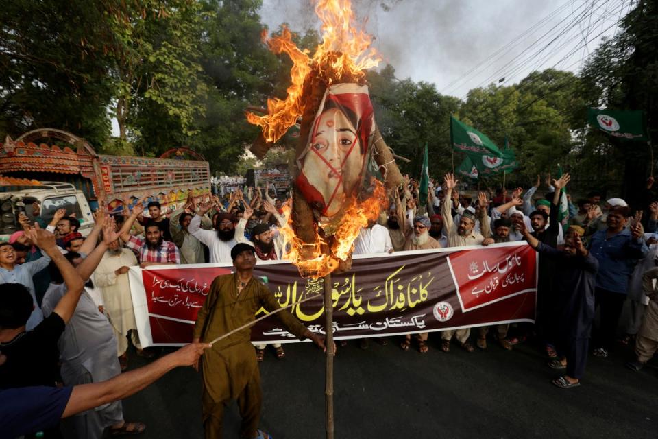 Supporters of a religious group burn a picture of BJP member Nupur Sharma during a demonstration in Lahore, Pakistan, on 12 June to condemn derogatory references to Islam made by her (AP)