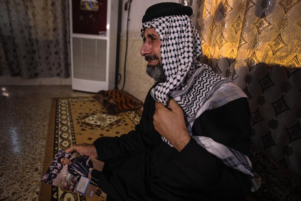 Jasb Hattab Aboud, father of the kidnapped protester Ali Jasb, cries as he holds his son's picture in his home un the town of Amara,Iraq, Wednesday, July 29, 2020. Jasb Jasb was kidnapped last October in Amara by unknown assailants. Anti-government demonstrations witnessed tens of thousands of Iraqi youth railing against decades of corruption. Jasb was one of them, and like many other activists, the dramatic events had emboldened him to speak out against the powerful influence of militias in his hometown. (AP Photo/Nabil al-Jurani)