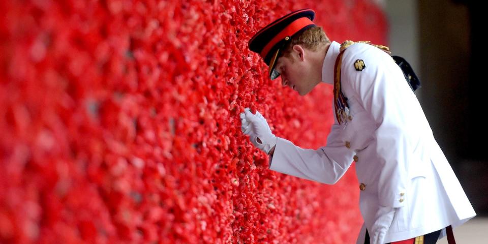 <p>The prince places a poppy at the Roll of Honour during a visit to the Australian War Memorial. </p>