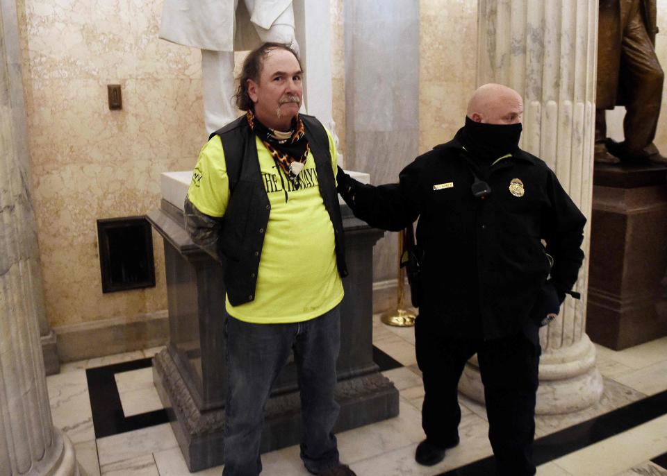 TOPSHOT - A supporter of President Trump is arrested inside the US Capitol in Washington DC on January 6, 2021. - Donald Trump's supporters stormed a session of Congress held today, January 6, to certify Joe Biden's election win, triggering unprecedented chaos and violence at the heart of American democracy and accusations the president was attempting a coup. (Photo by Olivier DOULIERY / AFP) (Photo by OLIVIER DOULIERY/AFP via Getty Images) ORG XMIT: 0 ORIG FILE ID: AFP_8YB49B.jpg