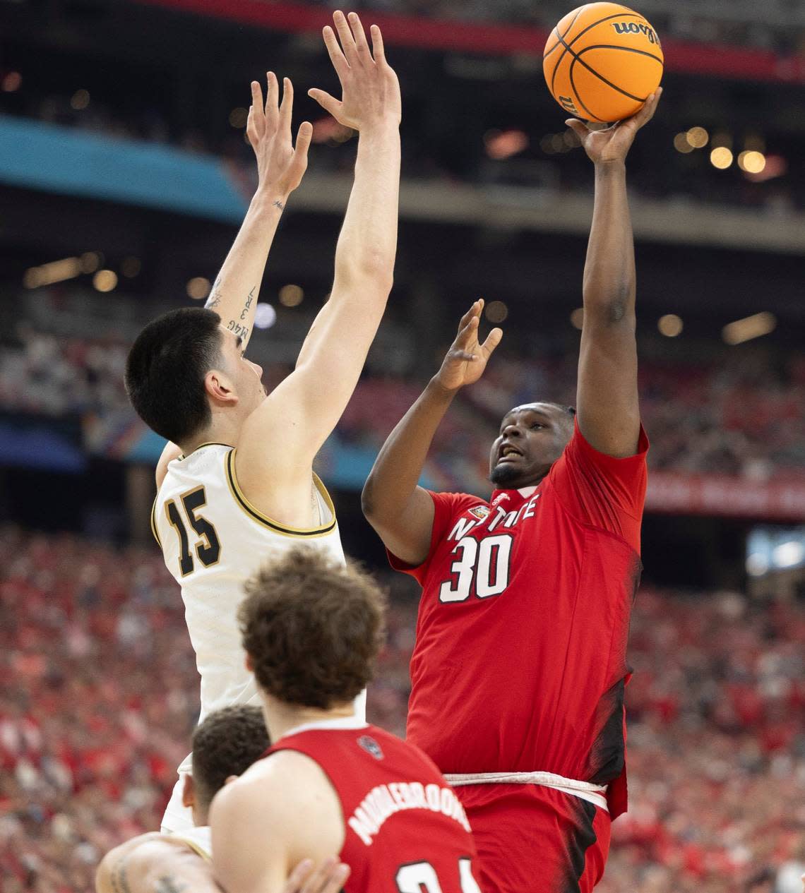 N.C. State’s D.J. Burns Jr. (30) puts up a shot against Purdue’s Zach Edey (15) during the first half in the NCAA Final Four National Semifinal game on Saturday, April 6, 2024 at State Farm Stadium in Glendale, AZ. Robert Willett/rwillett@newsobserver.com
