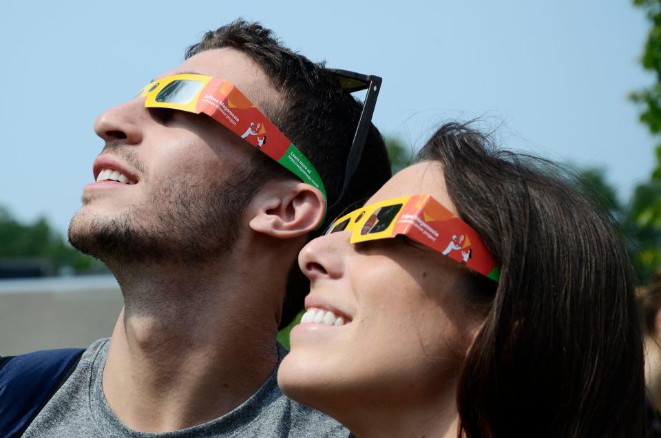 Jason Sherbel (left) and Mary Bender, from Ann Arbor, watch the 2017 solar eclipse from the Petoskey District Library.