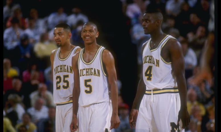 Michigan Wolverines forward Juwan Howard, guard Jalen Rose, and forward Chris Webber (l to r) look on during a game against Indiana.