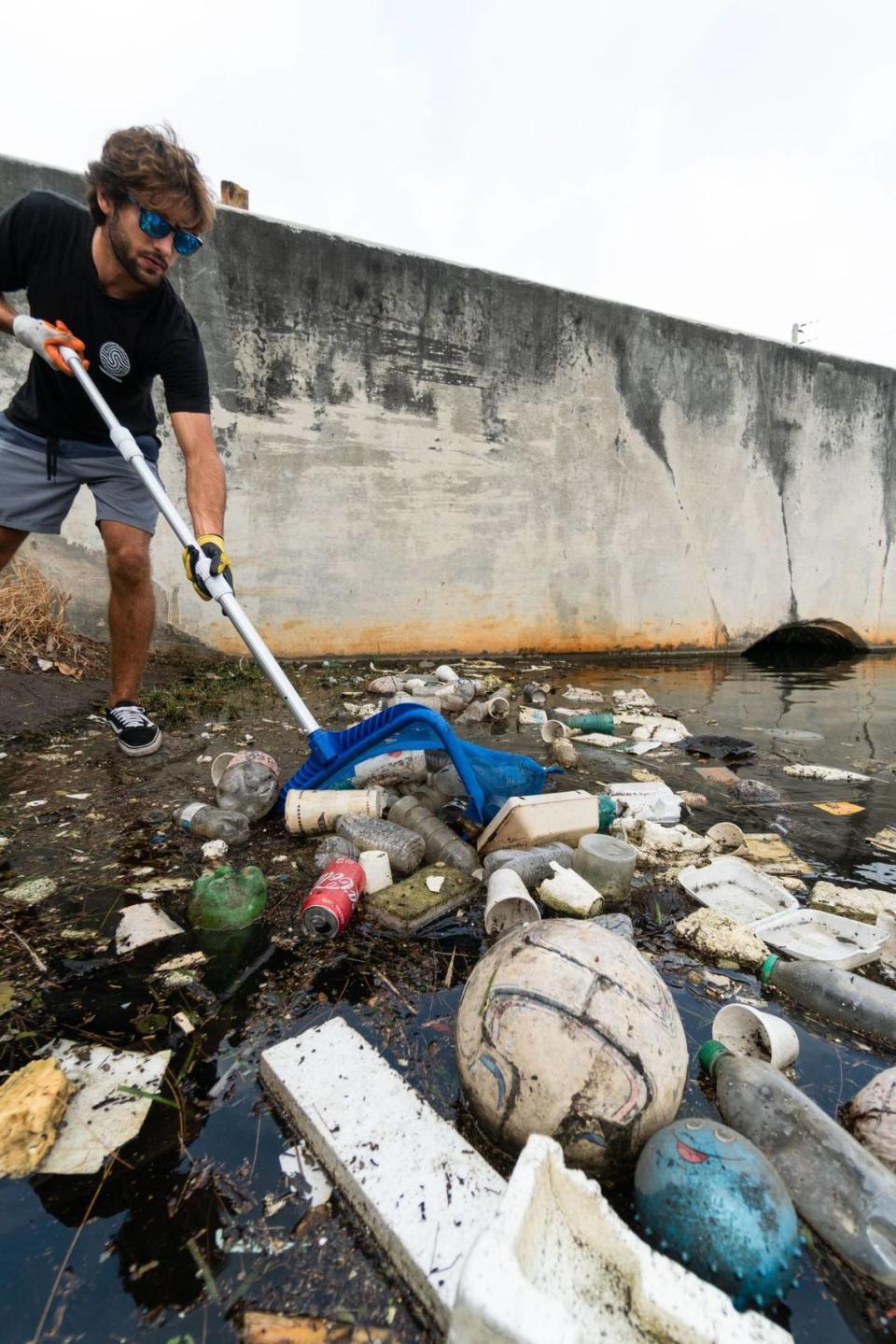 Sendit4thesea co-founder Coby Barreras cleans out a canal in Opa-locka.