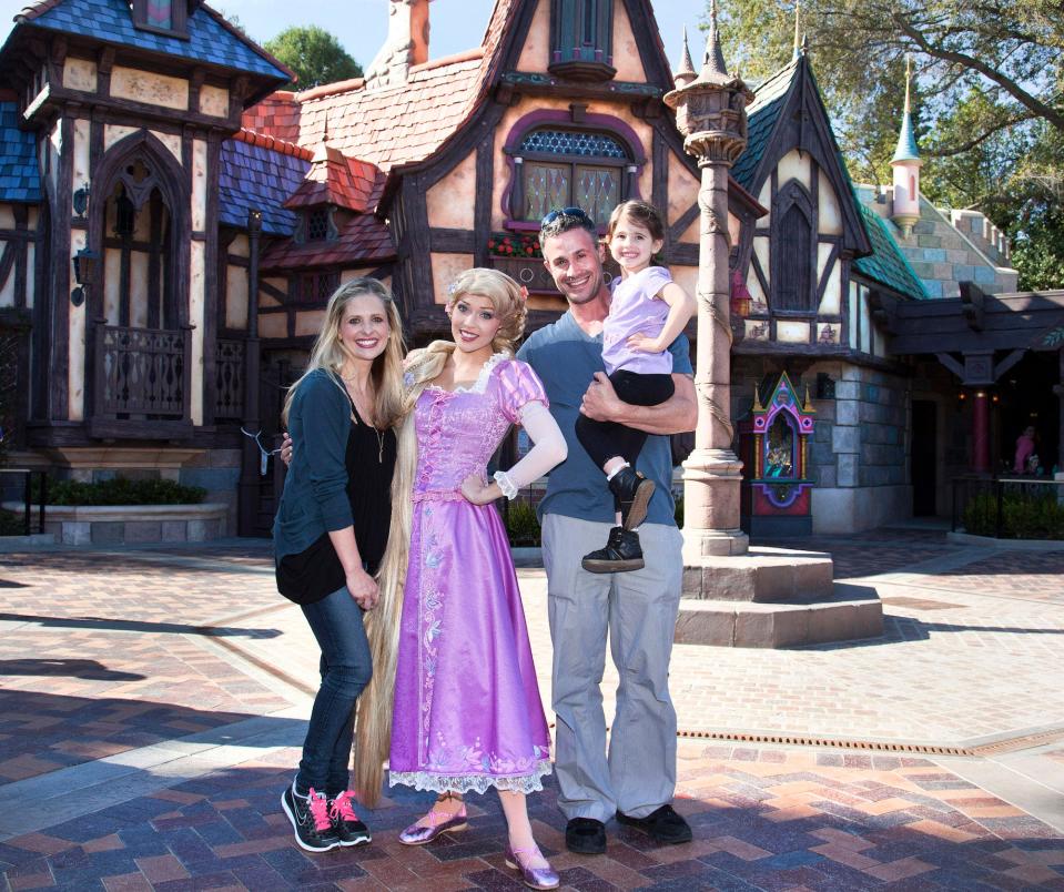 Sarah Michelle Gellar, Freddie Prinze Jr., and their daughter pose with Rapunzel at Disneyland.