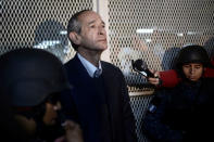 Former Guatemalan President Alvaro Colom looks on while escorted by policemen after being detained as part of a local corruption investigation, in Guatemala City, Guatemala February 13, 2018. REUTERS/Fabricio Alonzo