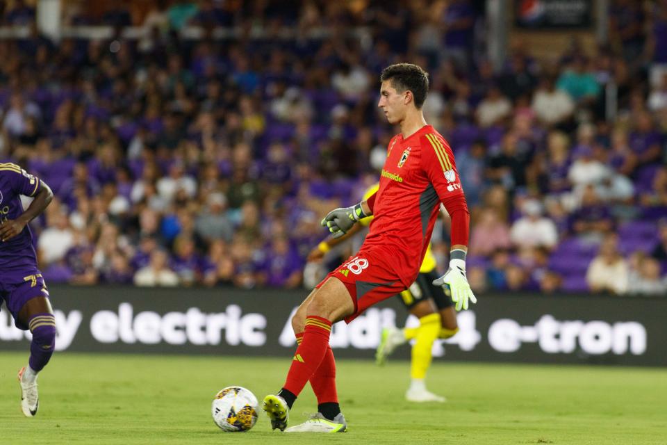 Sep 16, 2023; Orlando, Florida, USA; Columbus Crew goalkeeper Patrick Schulte (28) passes the ball against Orlando City SC midfielder Ivan Angulo (77) in the first half at Exploria Stadium. Mandatory Credit: Morgan Tencza-USA TODAY Sports