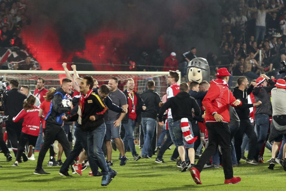 Supporters of FC Union Berlin celebrate after the soccer match with VfB Stuttgart in Berlin, Germany, Monday May 27, 2019. FC Union Berlin secured promotion to the Bundesliga. (Andreas Gora/dpa via AP)