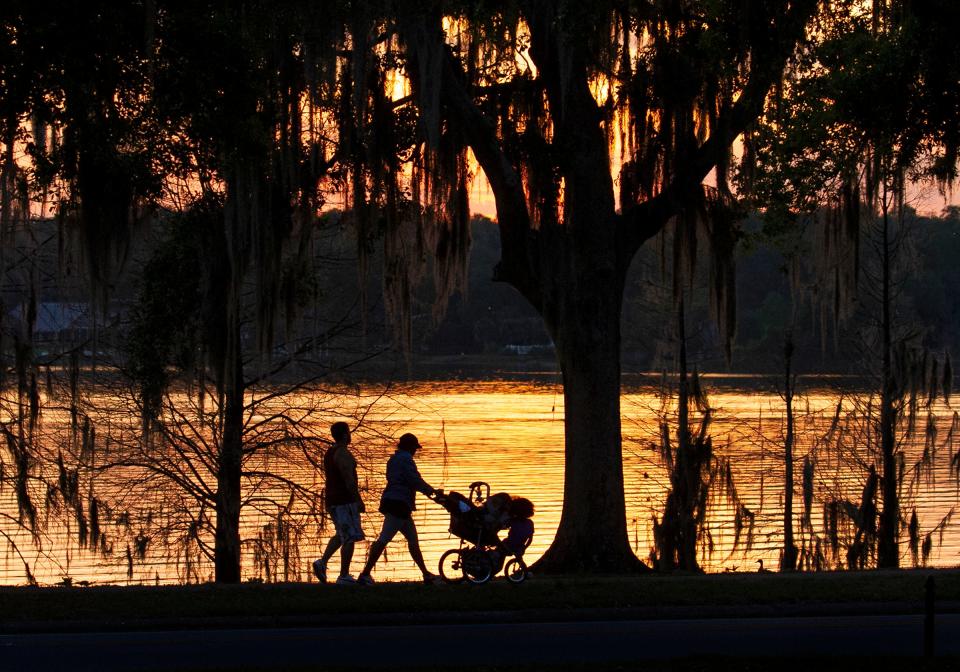 Lakeland residents enjoy a stroll around Lake Hollingsworth as the sun sets.