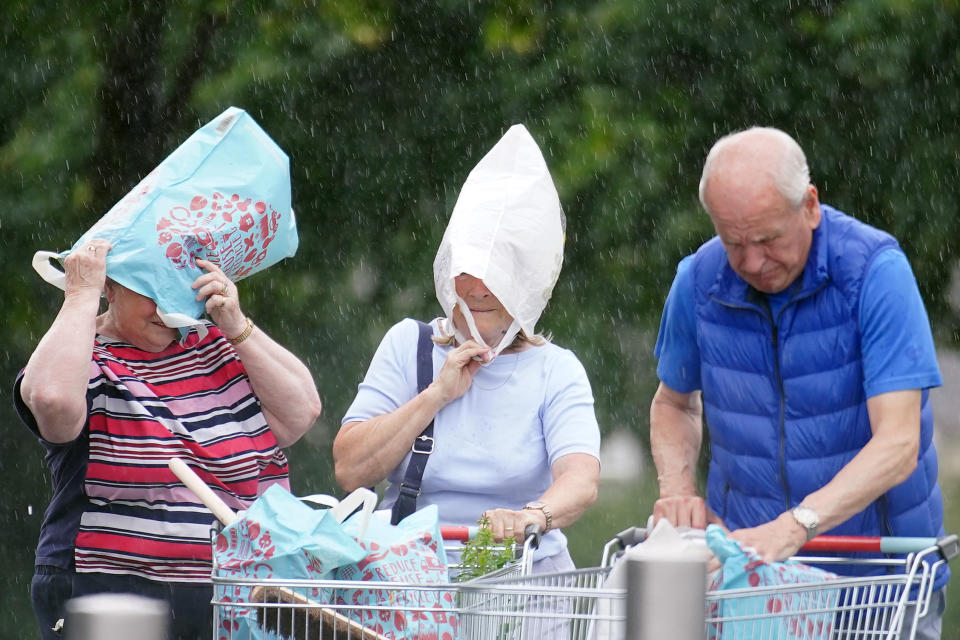 Two women protect themselves from the heavy rain in Speke, Liverpool. Picture date: Saturday July 8, 2023. The UK is facing thunderstorms and heavy rain as forecasts that the country could see the hottest of the year were changed. (Photo by Peter Byrne/PA Images via Getty Images)