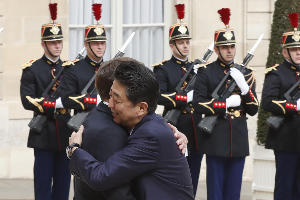 French President Emmanuel Macron, left, hugs Japan's Prime Minister Shinzo Abe before their talks at the Elysee Palace, Tuesday, April 23, 2019 in Paris. (AP Photo/Thibault Camus)