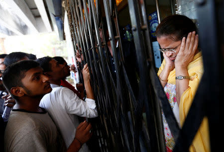 A bank employee reacts as people shout while they wait to enter a bank in Mumbai, November 10, 2016. REUTERS/Danish Siddiqui