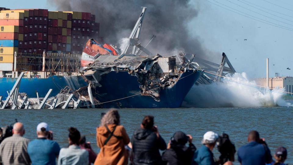 PHOTO: Explosive charges are detonated to bring down sections of the collapsed Francis Scott Key Bridge resting on the container ship Dali, May 13, 2024, in Baltimore.  (Mark Schiefelbein/AP)