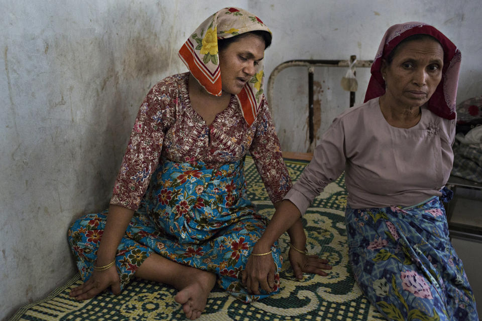 SITTWE, BURMA - MAY 06: Amina Khertu (left), 30, waits for a Rakhine doctor to arrive to deliver her child. The doctors had already left for the day and she was forced to wait for almost twelve hours on May 6, 2014 in Sittwe, Burma. Some 150,000 Rohingya IDP (internally displaced people) are currently imprisoned in refugee camps outside of Sittwe in Rakhine State in Western Myanmar. Medecins Sans Frontieres (MSF), the primary supplier of medical care within the camps, was banned in March by the Myanmar government. Follow up attacks by Buddhist mobs on the homes of aid workers in Sittwe put an end to NGO operations in the camps. Though some NGOs are beginning to resume work, MSF remains banned, and little to no healthcare is being provided to most Rohingya IDPs. One Rohingya doctor is servicing 150,000 refugees with limited medication. Several Rakhine volunteer doctors sporadically enter the camps for two hours a day. Births are the most complicated procedures successfully carried out in the camps, requests to visit Yangon or Sittwe hospitals for life threatening situations require lengthy applications and are routinely denied. Malnutrition and diarrhea are the most widespread issues, but more serious diseases like tuberculosis are going untreated and could lead to the rise of drug resistant tuberculosis (DR-TB).  (Photo by Andre Malerba/Getty Images)