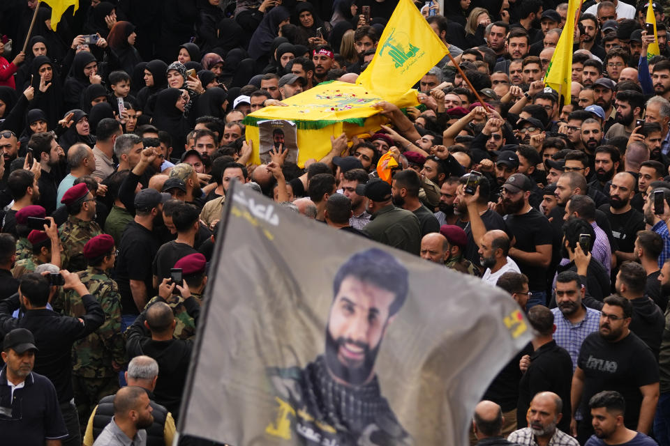 Hezbollah fighters carry the coffin of their comrade, Mohammed Ali Assaf, who was killed by an Israeli strike in Syria Friday morning, during his funeral procession in the southern Beirut suburb of Dahiyeh, Lebanon, Saturday, Nov. 11, 2023. Lebanon's militant Hezbollah group has announced the death of seven of its fighters without giving details on where they were killed. A Hezbollah official and a Lebanese security official said the seven fighters were killed in neighboring Syria Friday morning. (AP Photo/Hassan Ammar)