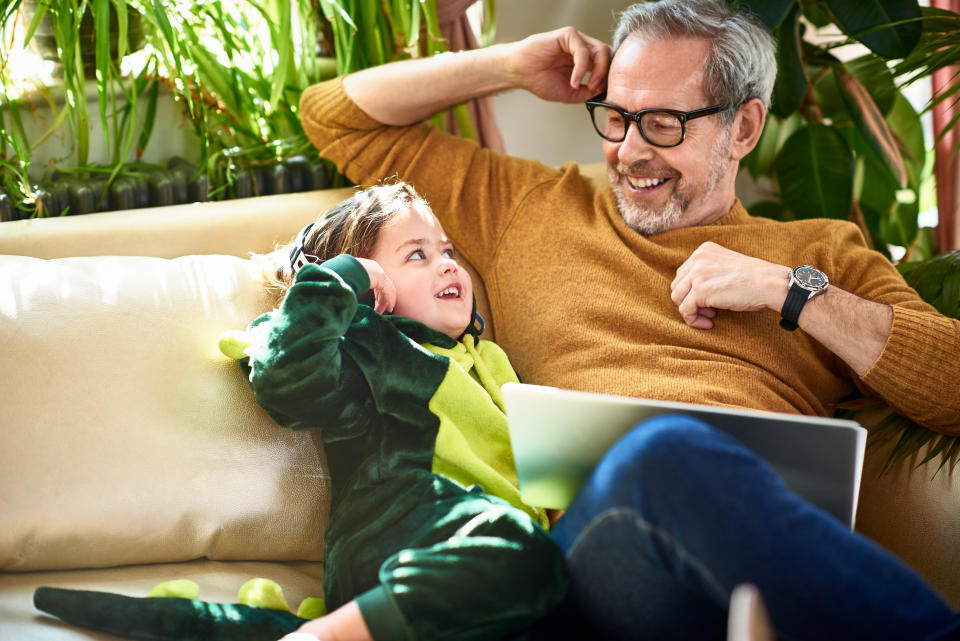 Modern grandfather sitting with granddaughter having fun and relaxing, childcare, connections, role model