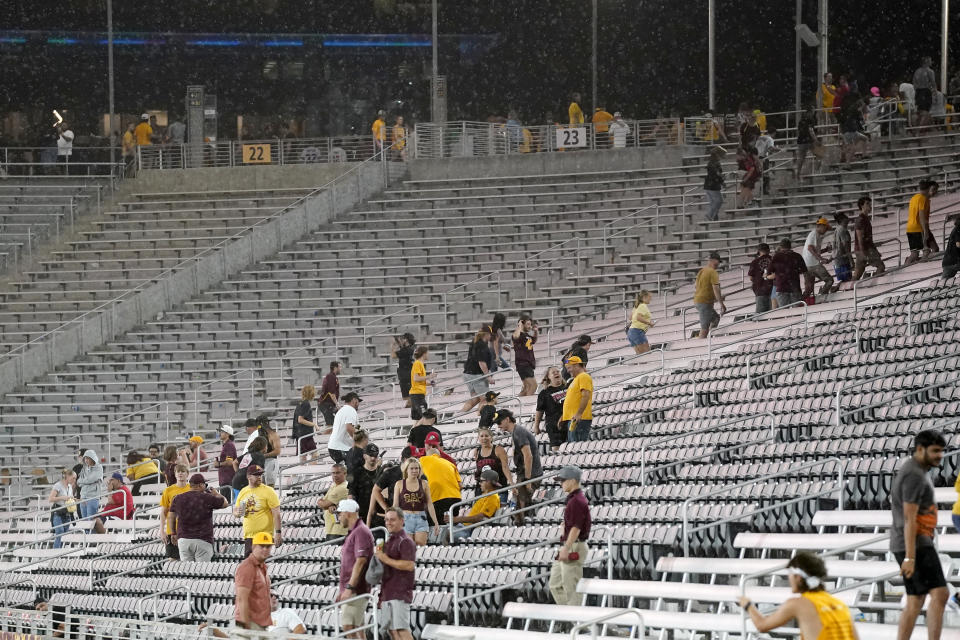 Fans exit the stadium during a weather delay at an NCAA college football game between Arizona State and Southern Utah on Thursday, Aug. 31, 2023, in Tempe, Ariz. (AP Photo/Ross D. Franklin)