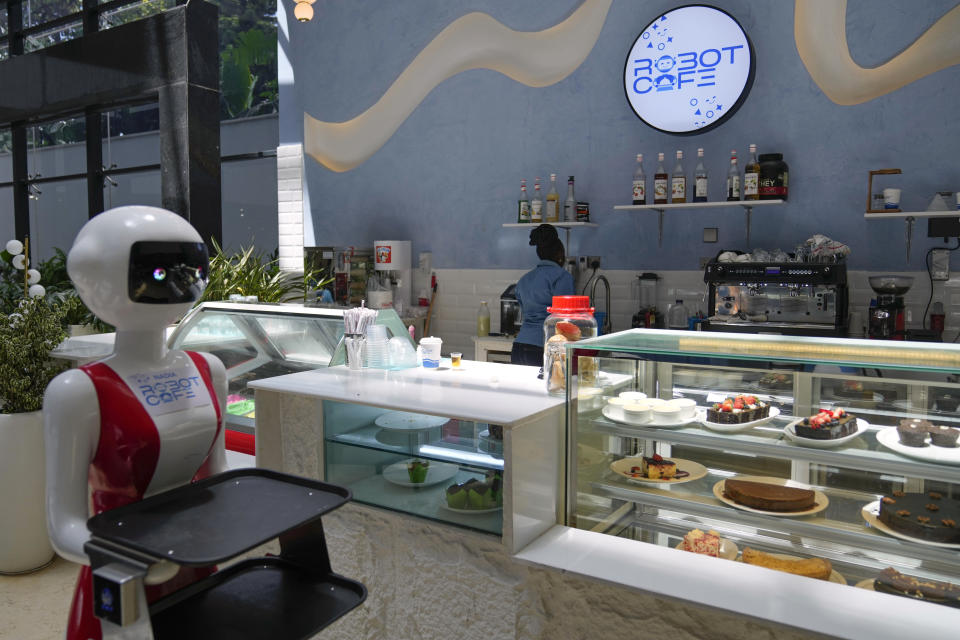 Robotic waiter stands beside the counter, at Robot Cafe in Nairobi, Kenya Thursday, Aug. 29, 2024. The three robots, christened Claire, R24 and Nadia, are not programmed to have a full conversation with customers, but they can say "Your order is ready, Welcome" then people have to press an exit button after picking up their food from the tray. (AP Photo/Brian Inganga)