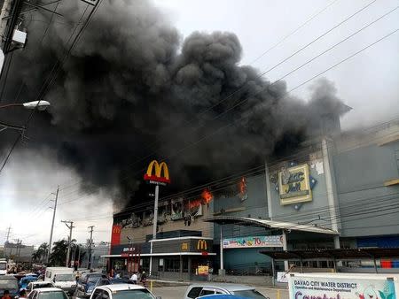 Smoke billows from a shopping mall on fire in Davao City, the Philippines, in this December 23, 2017 photo obtained from social media. Yas D. Ocampo/via REUTERS