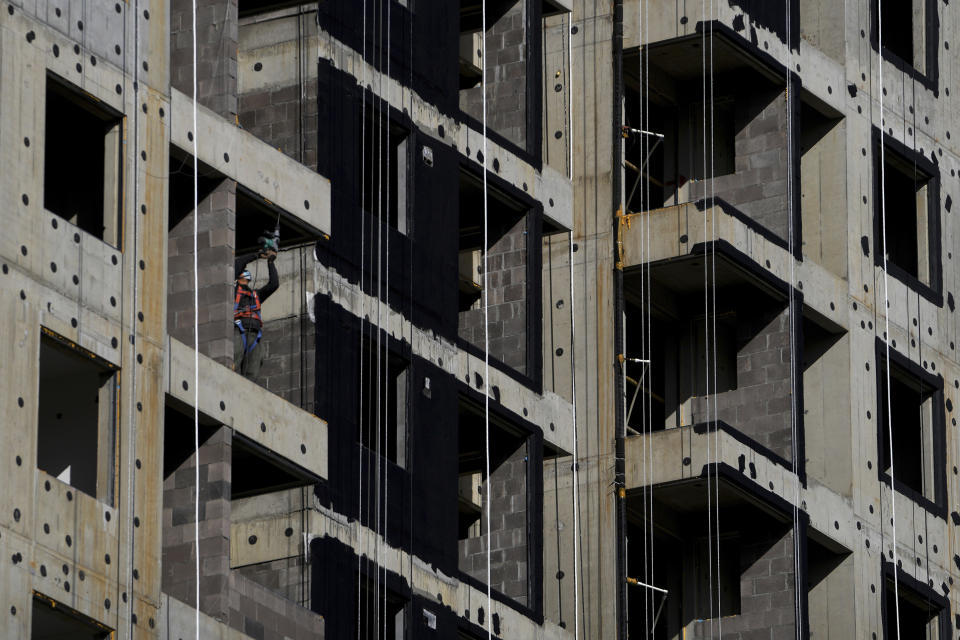 A worker wearing a face mask drills on a new apartment buildings under construction in Beijing on Oct. 26, 2021. China’s economic rebound from the coronavirus pandemic is stalling as President Xi Jinping’s government cracks down on surging corporate debt. (AP Photo/Andy Wong)