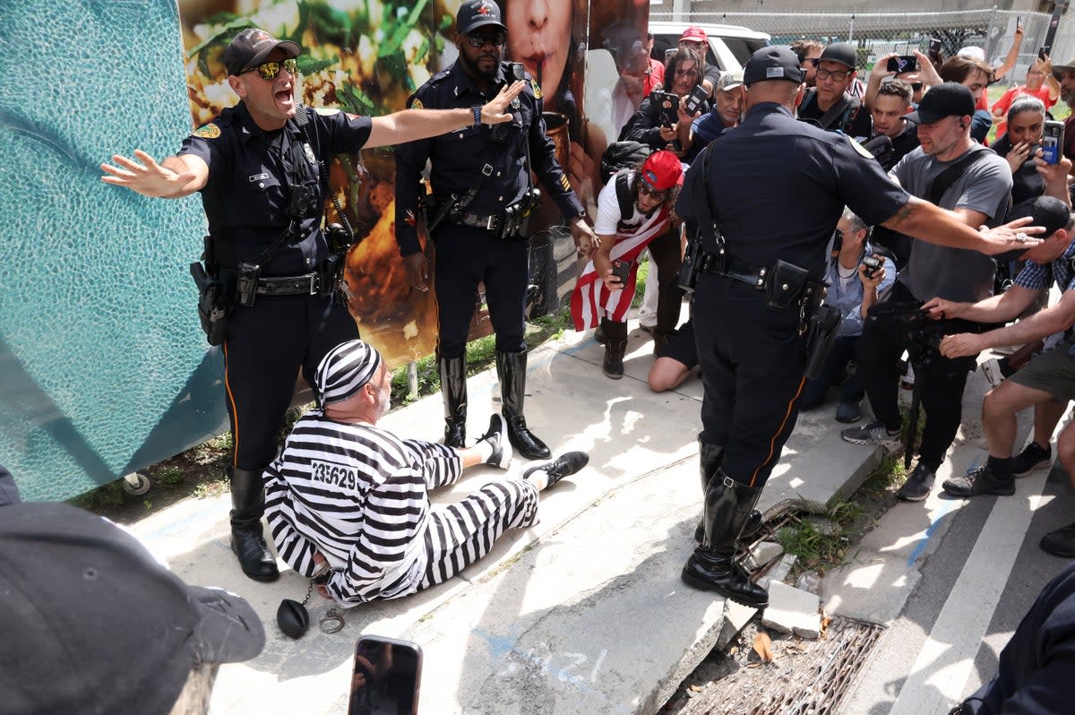 Miami Police officers control a crowd after detaining protester Dominic Santana, who attempted to rush former President Donald Trump's motorcade (Getty Images)