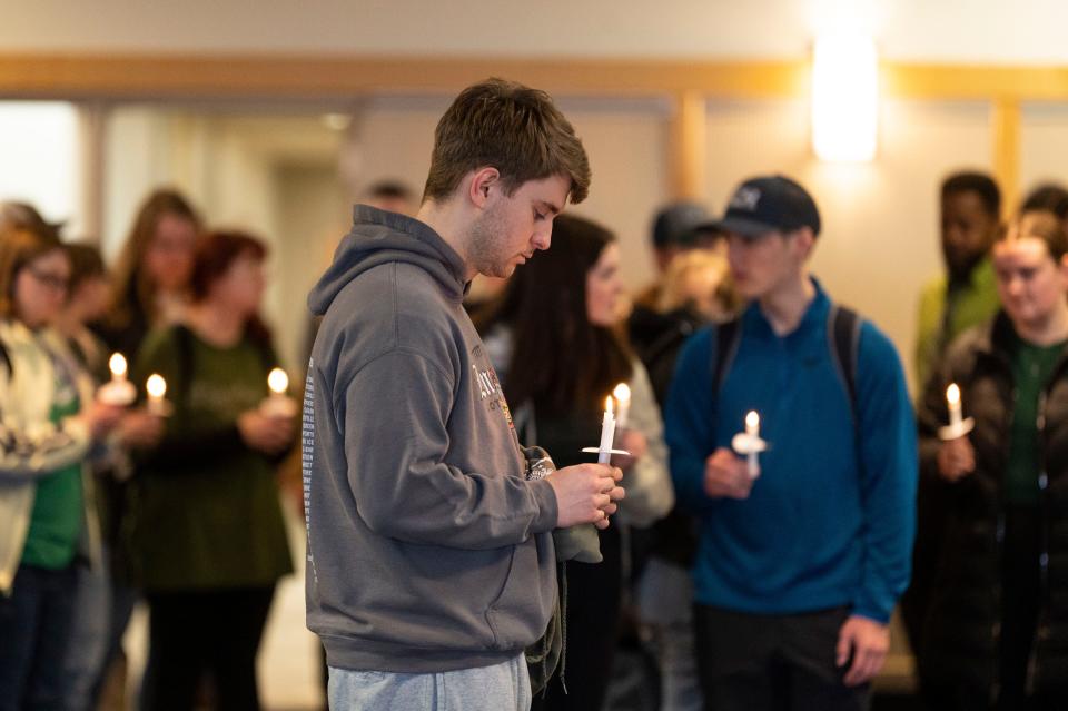 WMU student Logan Miller holds a candle during a vigil honoring Michigan State University mass shooting victims at Western Michigan University in Kalamazoo on Wednesday, Feb. 15, 2023.