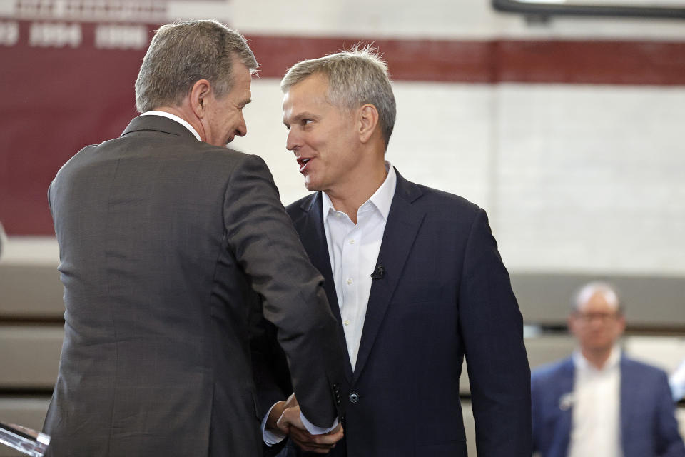 FILE - Democratic North Carolina gubernatorial candidate Josh Stein, right, is welcomed to the stage following an introduction by North Carolina Governor Roy Cooper, left, at a rally at Shaw University in Raleigh, N.C., Tuesday, Oct. 10, 2023. While taking dramatically different paths, Stein and Lt. Gov. Mark Robinson have emerged as frontrunners for their parties' nominations for governor next month in the race to succeed term-limited Democrat Roy Cooper in the nation's ninth largest state.(AP Photo/Karl B DeBlaker, File)