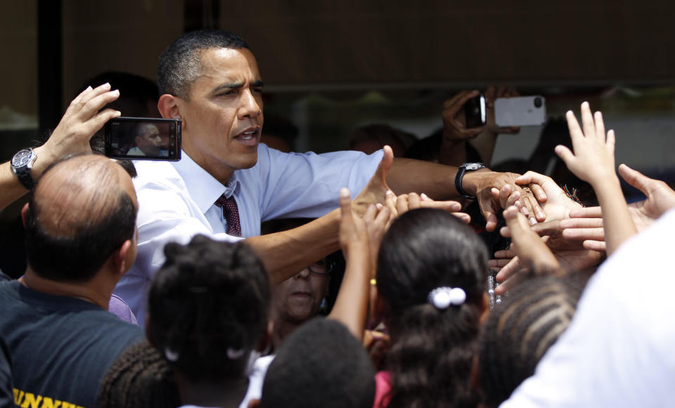 FILE - In this Aug. 2, 2012 file photo, President Barack Obama greets people outside Lechonera El Barrio, a local restaurant in Orlando, Fla. Florida's economy is center stage in Obama and Mitt Romney's high-stakes campaign for the rich trove of 29 electoral votes. One of the biggest prizes still up for grabs, this state, a hard-fought White House battleground in 2000, could be just as pivotal this year. (AP Photo/Pablo Martinez Monsivais, File)