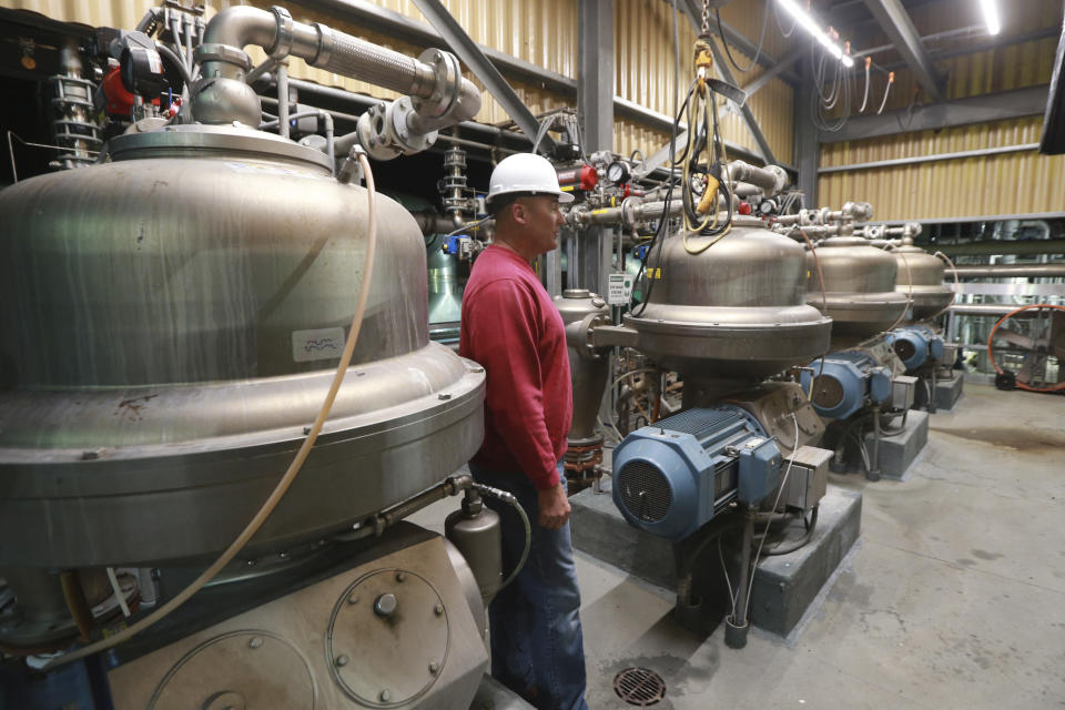 Omega Protein's Operations Manager, Monty Deihl, looks over production equipment at the menhaden processing plant on Cockrell's Creek in Reedville, Va., Tuesday, Nov. 26, 2019. The last east coast fishery now produces fish oil for health supplements and faces a possible moratorium over concerns about overfishing in the Chesapeake Bay. (AP Photo/Steve Helber)
