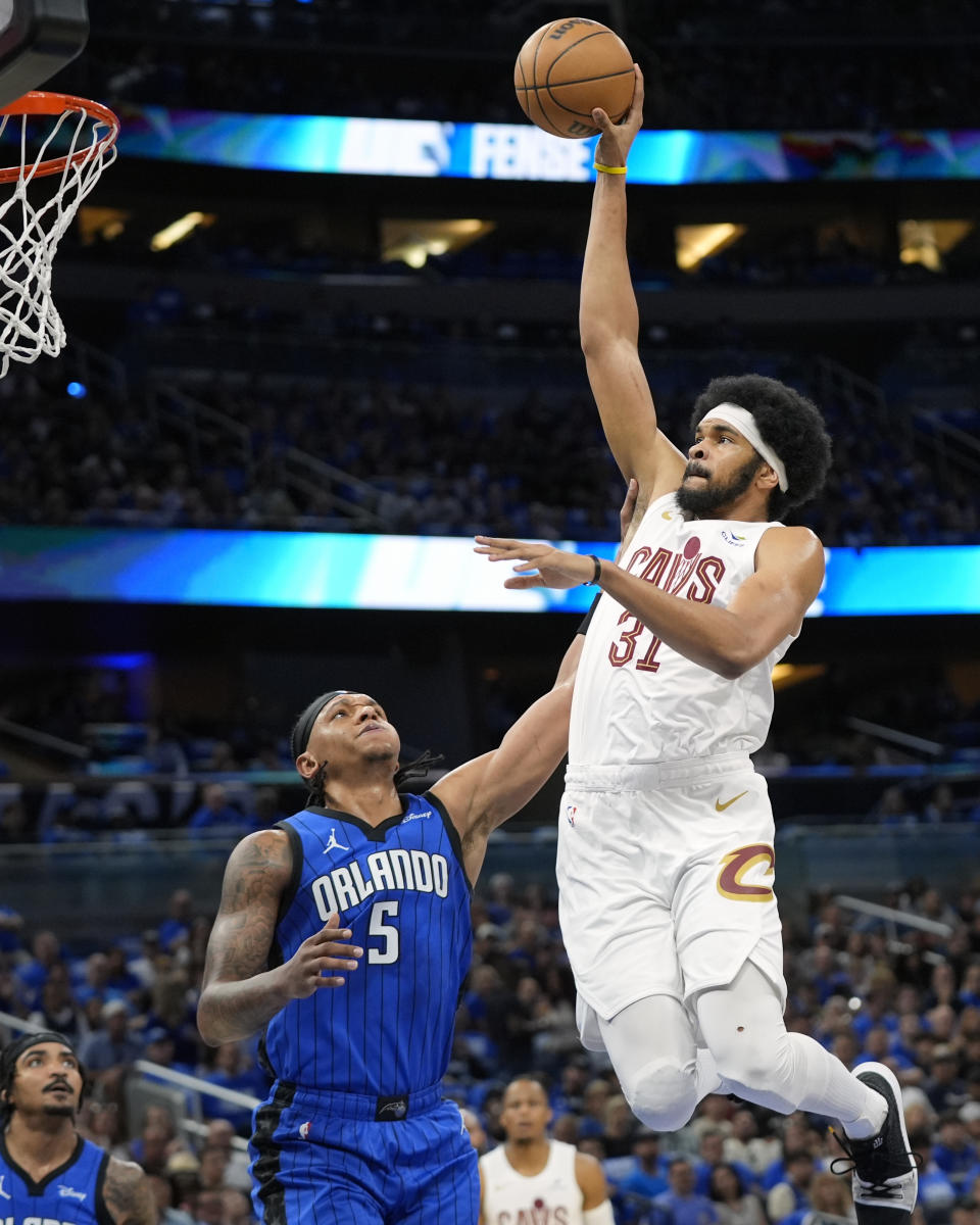 Cleveland Cavaliers center Jarrett Allen (31) goes over Orlando Magic forward Paolo Banchero (5) for a dunk during the first half of Game 4 of an NBA basketball first-round playoff series, Saturday, April 27, 2024, in Orlando, Fla. (AP Photo/John Raoux)