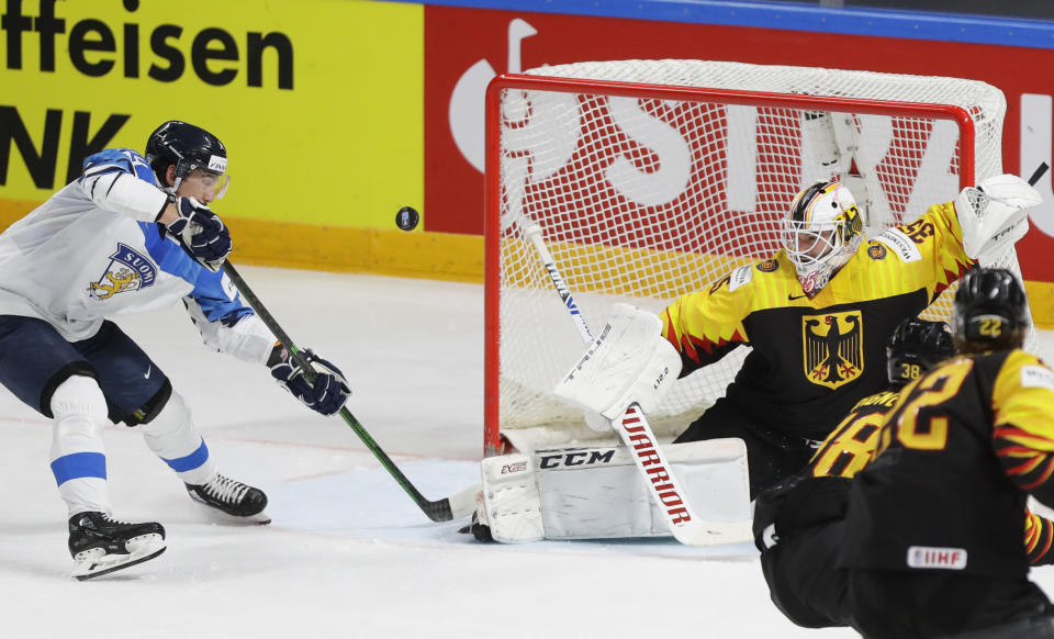 Finland's Hannes Bjorninen, left, tries to score against Germany's goaltender Mathias Niederberger during the Ice Hockey World Championship group B match between Germany and Finland at the Arena in Riga, Latvia, Saturday, May 29, 2021. (AP Photo/Sergei Grits)