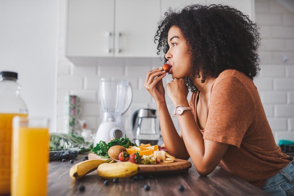 Shot of a young woman making a healthy snack with fruit at home