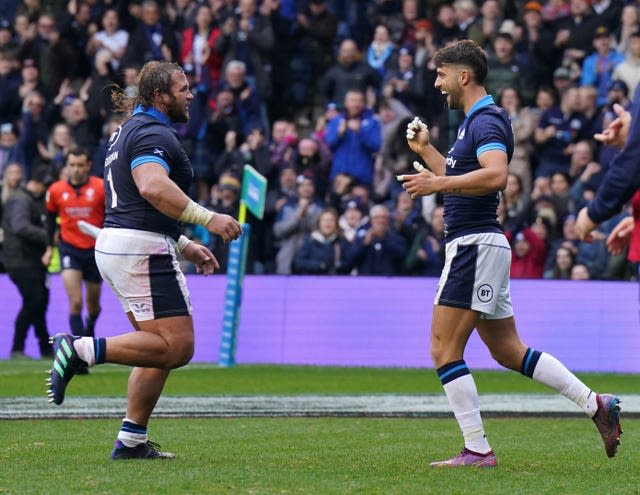 Adam Hastings (right) celebrates his try but was later forced off 