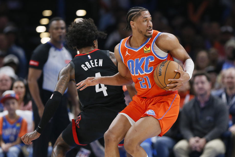 Oklahoma City Thunder guard Aaron Wiggins (21) spins away from Houston Rockets guard Jalen Green (4) during the second half of an NBA basketball game Wednesday, March 27, 2024, in Oklahoma City. (AP Photo/Nate Billings)